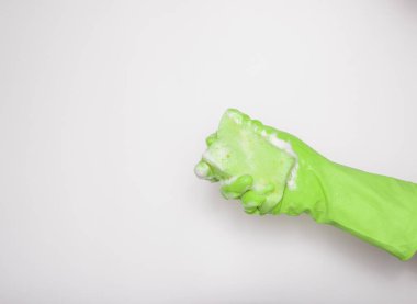 Yeşil lastik eldiven, yeşil sünger ve beyaz arka planda köpük. Bulaşık, temizlik, ev temizliği..