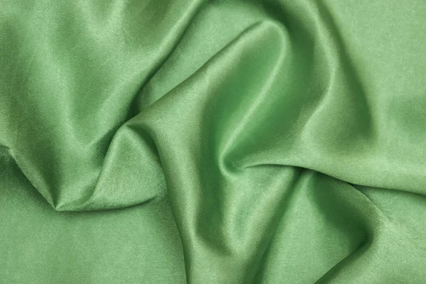 Smooth elegant green silk or satin luxury cloth texture can be used as an abstract background. Crumpled fabric.