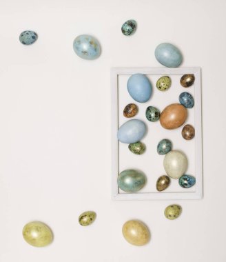 Boyanmış Paskalya yumurtaları, ahşap beyaz çerçeveli altın ve mavidir. Mesaj için yer var. Mutlu Paskalyalar!