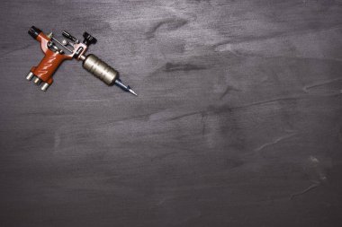 Siyah arka planda dönen dövme makinesi. Metin için boş alan. Üst görünüm.