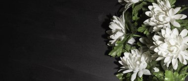 Funeral symbol. A bouquet of white flowers on the side, black background, free space for text. clipart