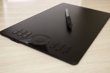 Grafik tablet ve Stylus masanın üzerinde duruyor. Yan görünüm, grafik çizim araçları.