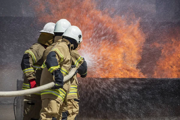 Brandweerlieden blussen van de brand huis — Stockfoto