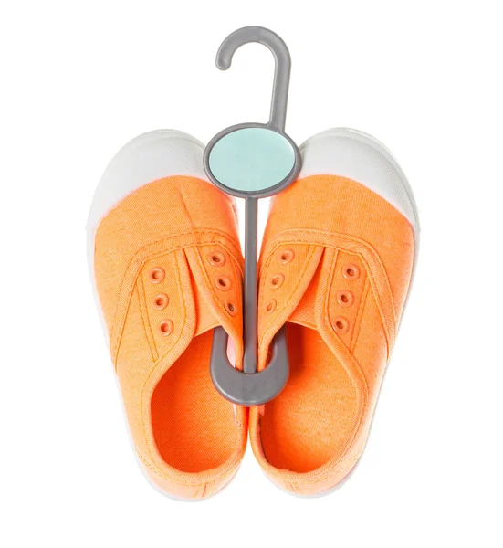 Оранжевые кроссовки на пластиковой вешалке . — стоковое фото