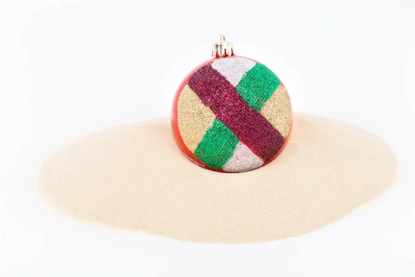 Bola de Natal colorido na areia . — Fotografia de Stock