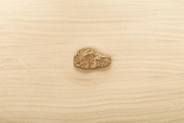 Pedra dourada na areia ondulada . — Fotografia de Stock