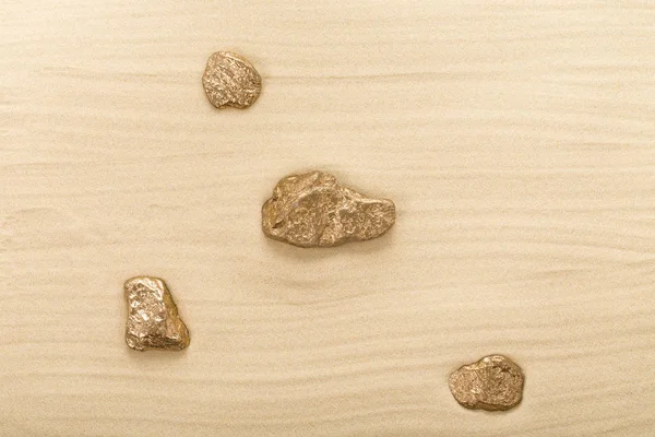Piedras doradas sobre arena ondulada . —  Fotos de Stock