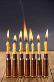 Hořící svíčky a prázdné náboje.