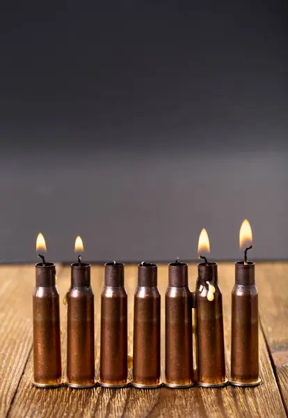 Velas ardientes y cartuchos de rifle vacíos . — Foto de Stock