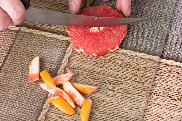 Grapefruit met mes snijden. — Stockfoto