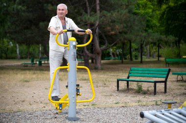 Yaşlı adam açık jimnastik egzersizleri yapma.