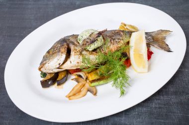 Tereyağı ve sebze ile pişmiş dorado.