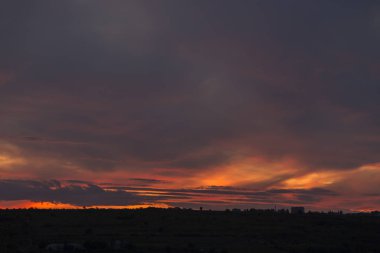 Bulutlu turuncu gökyüzü ile gün batımının manzarası.