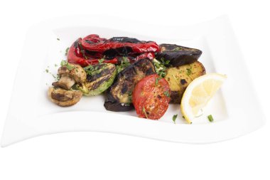 Beyaz tabakta ızgara sebze. Beyaz bir arka planda izole edilmiştir. Yakın plan..