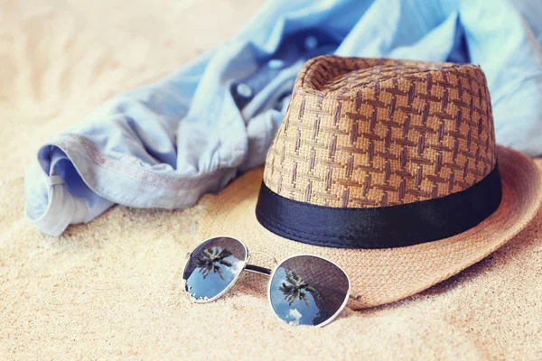 หมวกและแว่นกันแดดบนชายหาด — ภาพถ่ายสต็อก