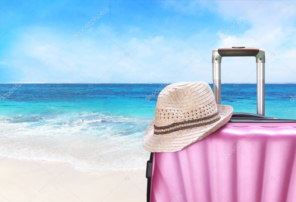 suitcase and hat on the beach