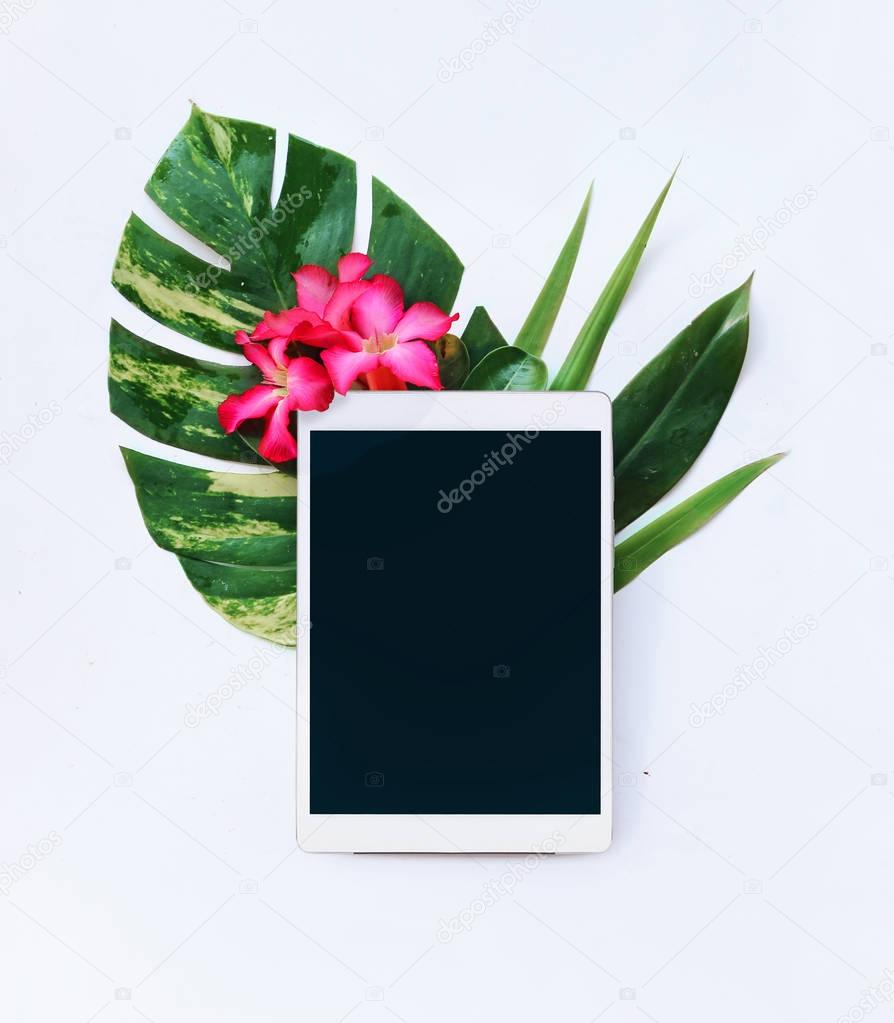 Tablet with tropical flowers on a white background