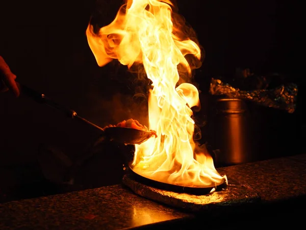 Chinese cook cooks meat in a roasting pan