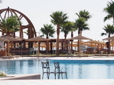 insanlar olmadan yaz aylarında sabah açık havuz kenarında iki metal sandalyeler