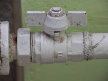 Şehir dairesinde musluğu olan eski dökme demir beyaz radyatör.