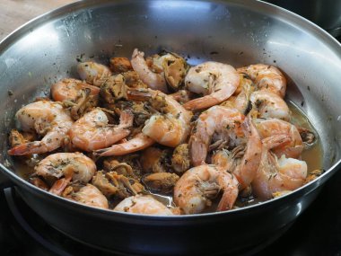 Tavada pişirilmiş midye ve karides.