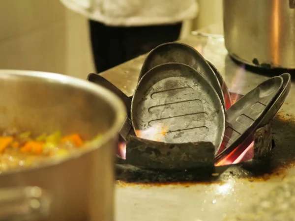 heating over an open fire of an iron frying pan for cooking meat in Chinese cuisine