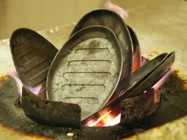 heating over an open fire of an iron frying pan for cooking meat in Chinese cuisine