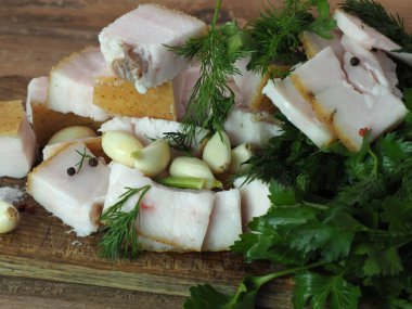 Tahtaya sarımsaklı, dereotlu, maydanozlu ve biberli dilimlenmiş pastırma.