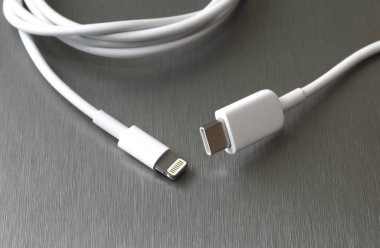Gri metal arka planda Usb tip C ve şimşek beyaz kablo bağlantısı