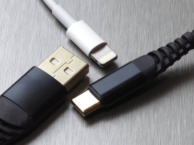 Gri metal arka planda Usb tip C ve yıldırım kablo bağlantısı