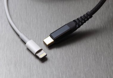 Gri metal arka planda Usb tip C ve yıldırım kablo bağlantısı