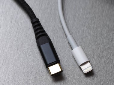 Gri metal arka planda Usb tip C ve yıldırım kablo bağlantısı