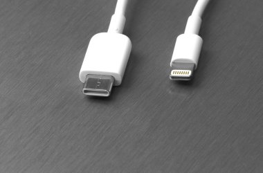 Gri metal arka planda Usb tip C ve şimşek beyaz kablo bağlantısı