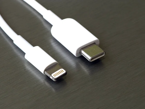 灰色金属背景上的Usb C型和闪电白色电缆连接器 — 图库照片