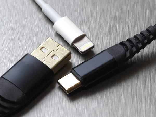 Gri metal arka planda Usb tip C ve yıldırım kablo bağlantısı