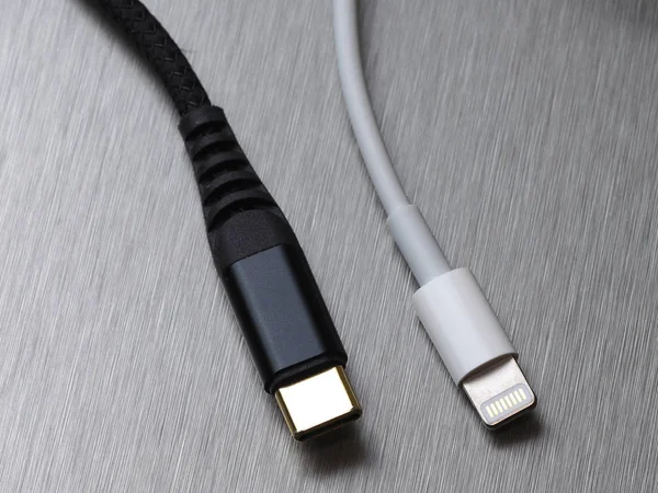 Gri metal arka planda Usb tip C ve yıldırım kablo bağlantısı