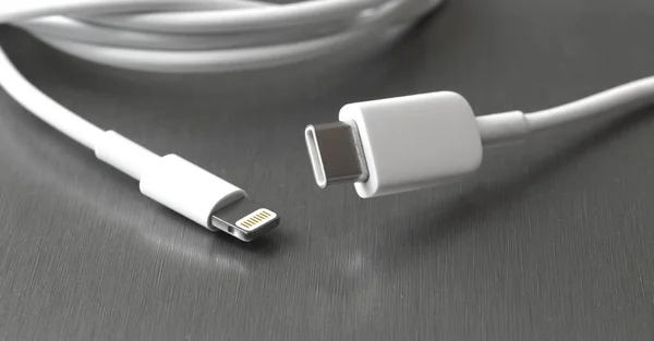 灰色金属背景上的Usb C型和闪电白色电缆连接器 — 图库照片