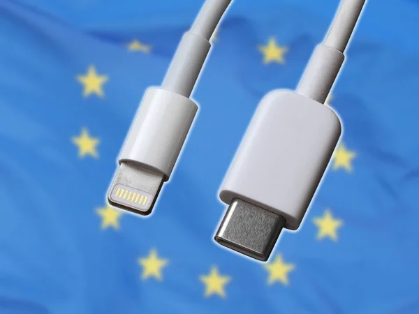 USB type C and lightning white cable connector on the background of the flag of the European Union