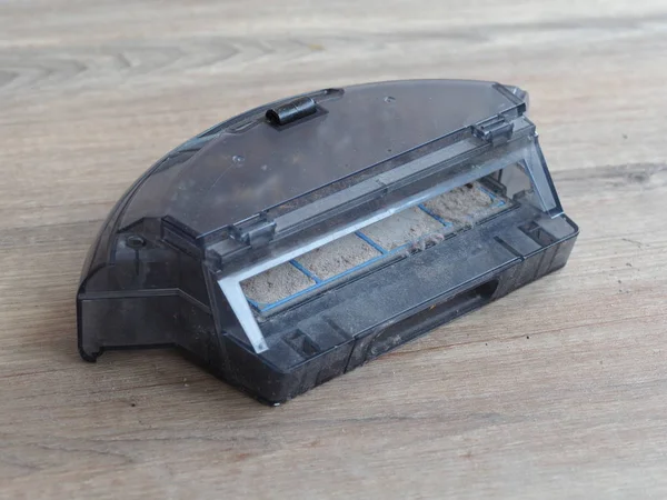 Cleaning the robot vacuum cleaner, filled garbage can cleaner, long hair wound on a robot  vacuum cleaner brush. 