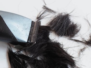 electric hair clipper on a trimmed dark hair background