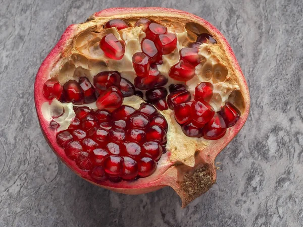 Sliced Ripe Pomegranate Fruit Kernels Close Gray Stone — Stok fotoğraf