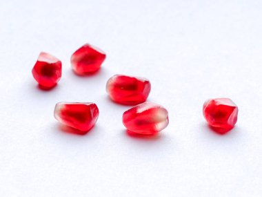 Dağınık nar tohumları beyaz arkaplanda izole edilmiş