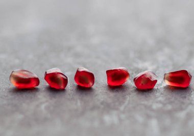 Gri bir taşın üzerine serpilmiş nar tohumları.