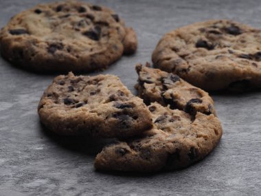 Gri bir taşın üzerinde çikolata parçalarıyla doldurulmuş ev yapımı kurabiyeler.