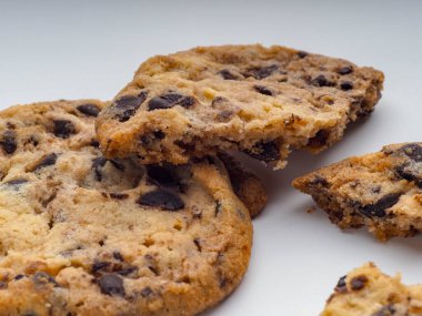 Beyaz arka planda çikolata parçalarıyla doldurulmuş ev yapımı kurabiyeler.