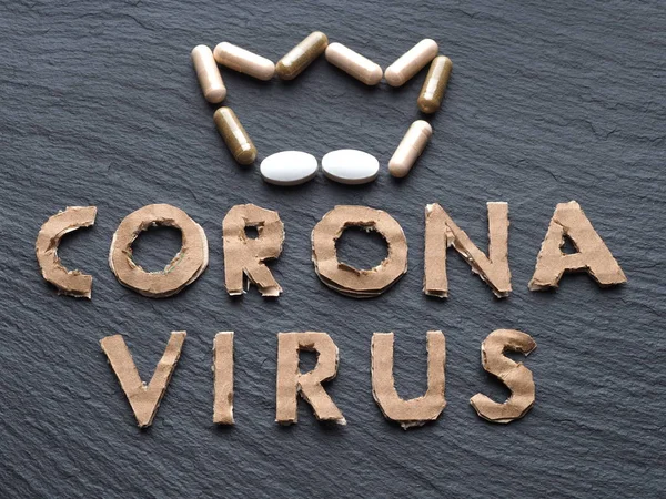 Siyah arkaplandaki karton koronavirüsten bir yazı. Taç ilaç ve vitaminli haplardan yapılmış. Yeni 2019-ncov Coronavirüs, Mers-Cov.