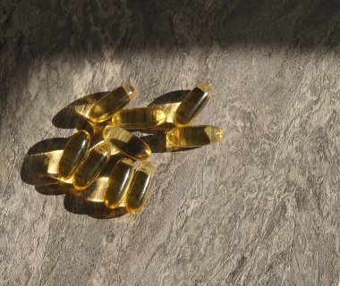 Gri taşlı arka planda birçok kapsül Omega 3. Sağlık hizmeti kavramı