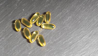 Gri taşlı arka planda birçok kapsül Omega 3. Sağlık hizmeti kavramı