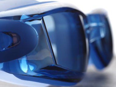 Gri arka planda yüzmek için profesyonel mavi gözlükler.