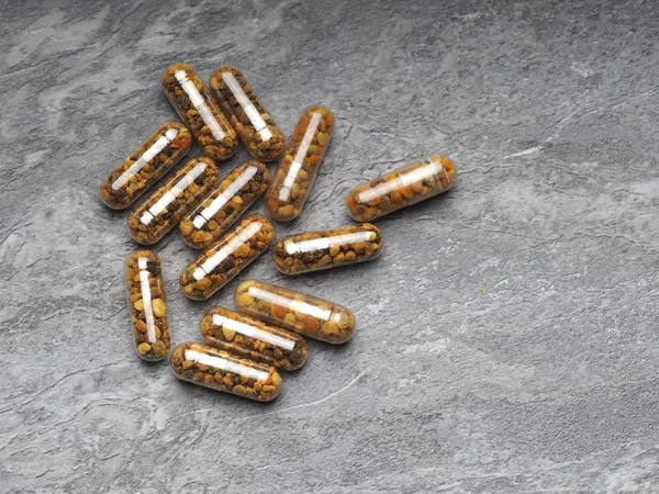 Bee pollen grains  in clear capsules for daily use. Healthy natural medicine for influenza.